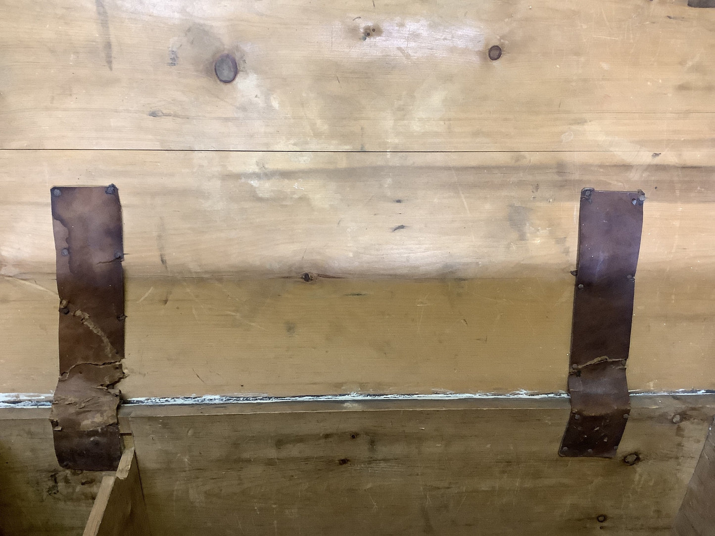 Old leather strips covering metal hinges